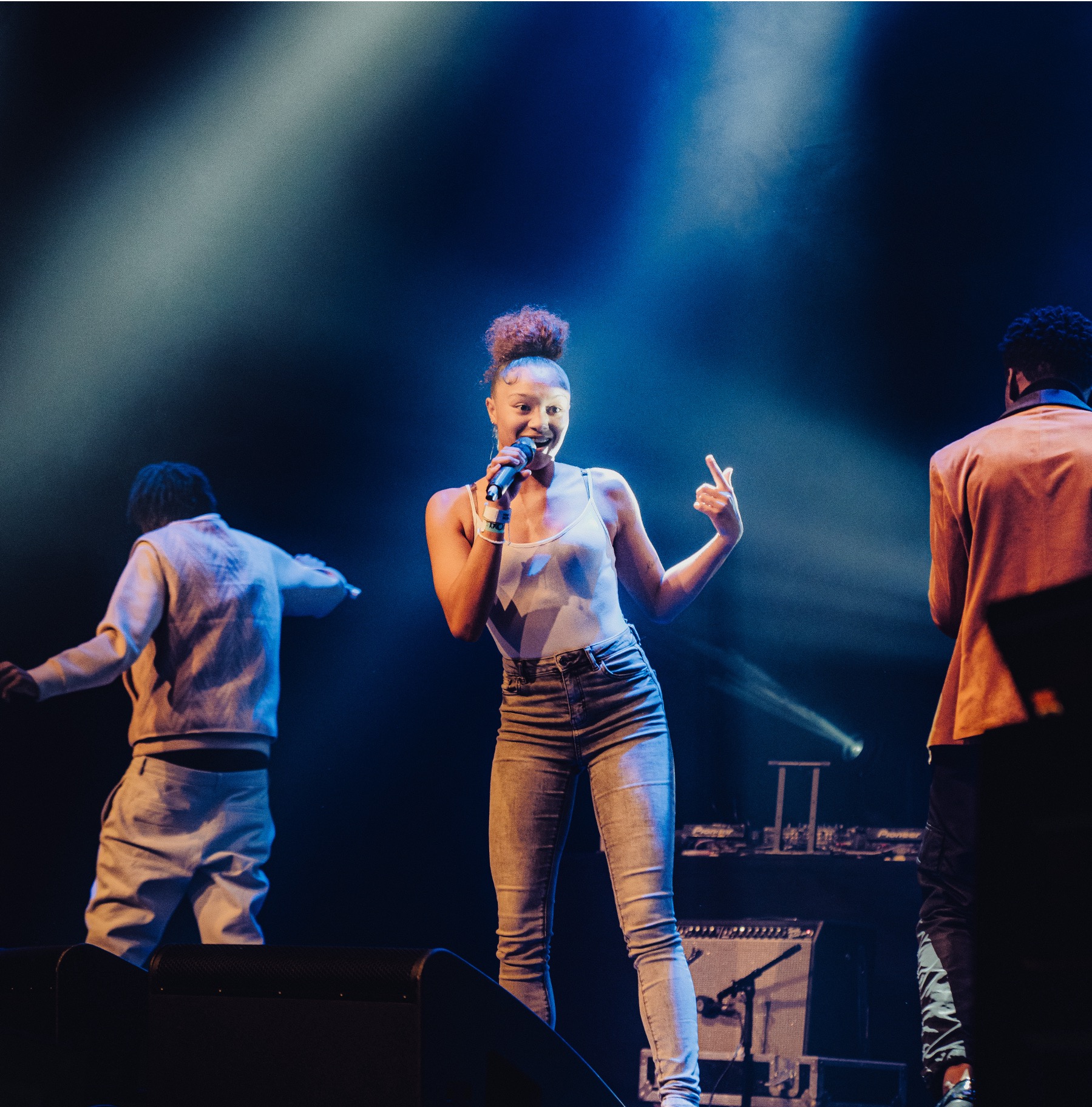 A young person singing into a microphone on stage