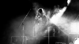 black and white photo of a young man on stage with a microphone