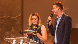 two young people with microphones on stage