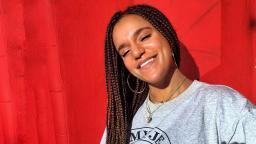 girl wearing grey tshirt in front of a red background