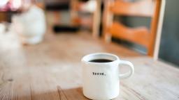 A coffee table with a mug of black coffee, with "Begin" written on the mug.