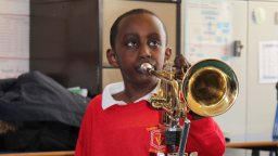 Young musician playing brass instrument with one hand