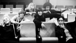 black and white photo of a group of women sitting on rows of chairs