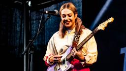 young person playing the guitar on stage