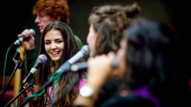 Young people singing into microphones