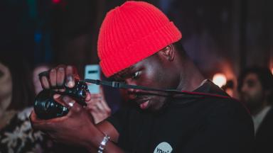 Photographer wearing red hat and Youth Music t-shirt