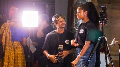 Two young people using camera equipment and lights