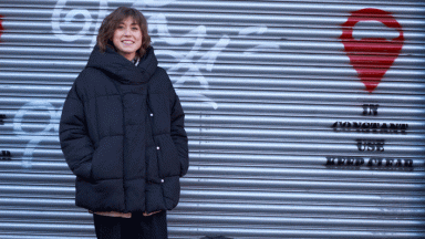 Person in coat stood in front of garage door