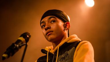 Young person wearing a yellow hoodie and a black durag