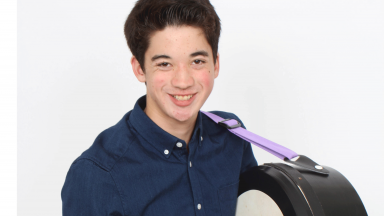 Young man holding a large drum