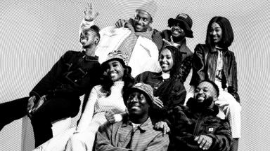 black and white photo of a group of people sitting together smiling