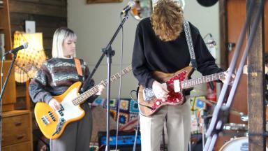 two young people playing guitars