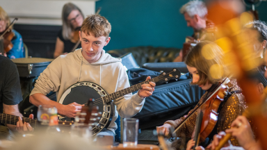 a boy plays a string instrument in a group