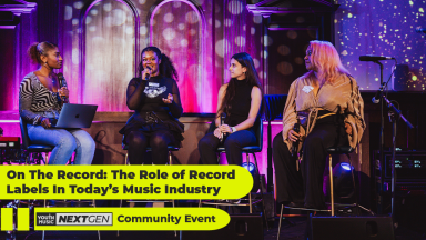 a group of women sit on stage as part of a panel