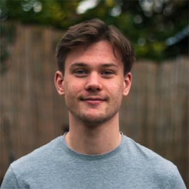 person standing outside with trees behind them