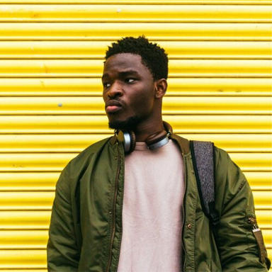 young person standing against striped yellow background