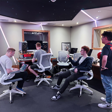 a group of four young men in a music studio