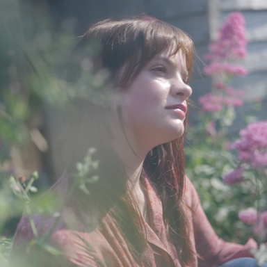 hannah sits in a garden of flowers