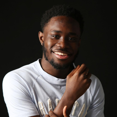 a guy wears a white t shirt and smiles